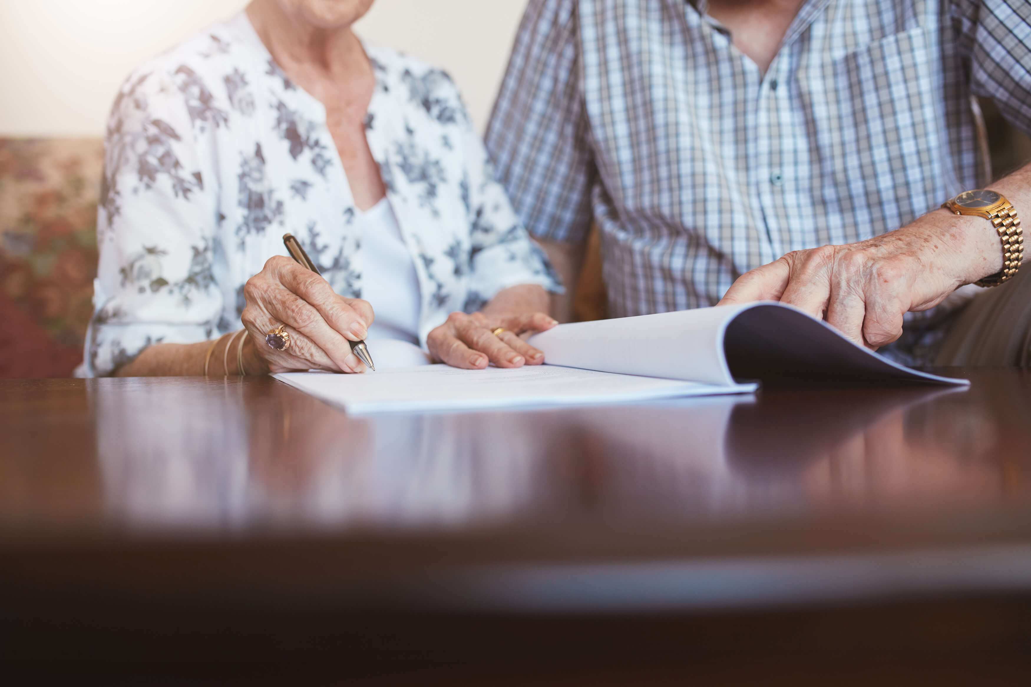 senior-woman-signing-documents-with-her-husband-2023-11-27-05-11-03-utc.jpg